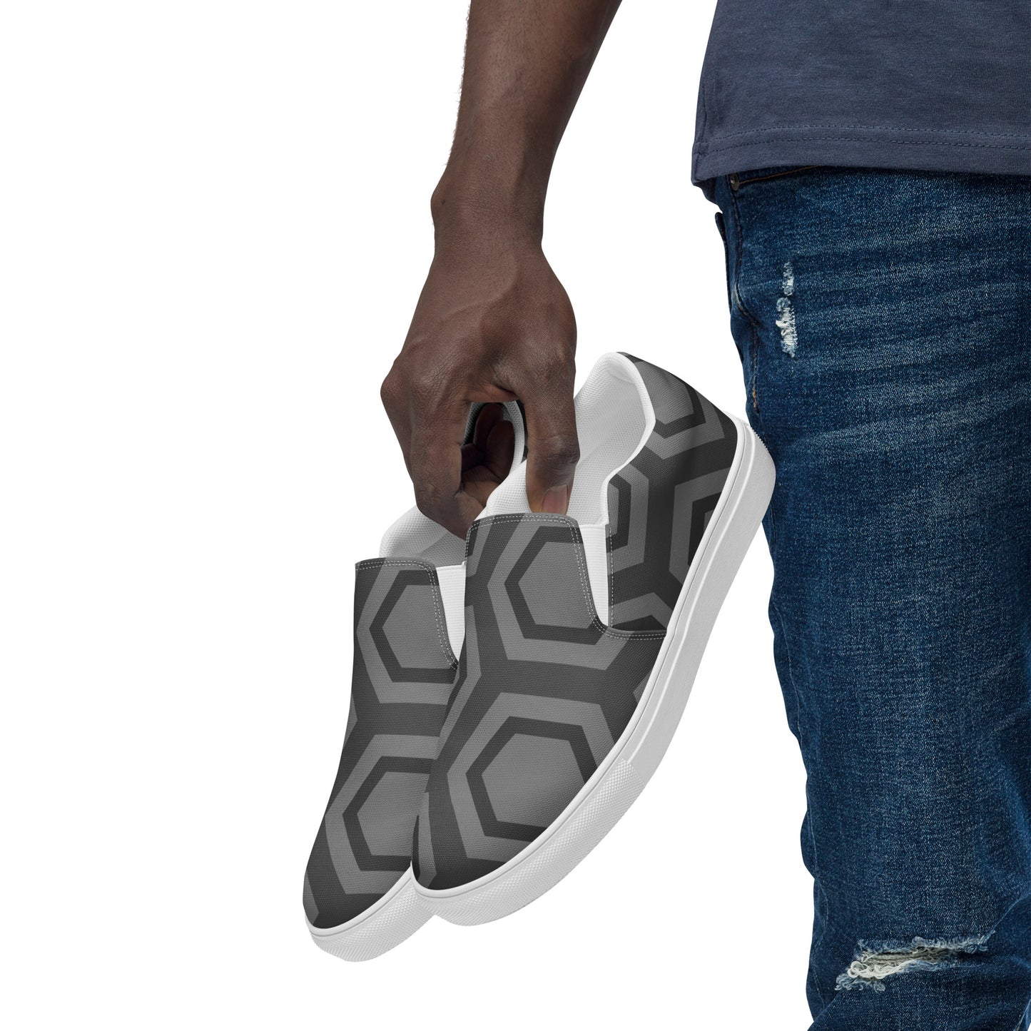 Comfortable men's slip-on loafers with gray geometric pattern held by person wearing blue jeans