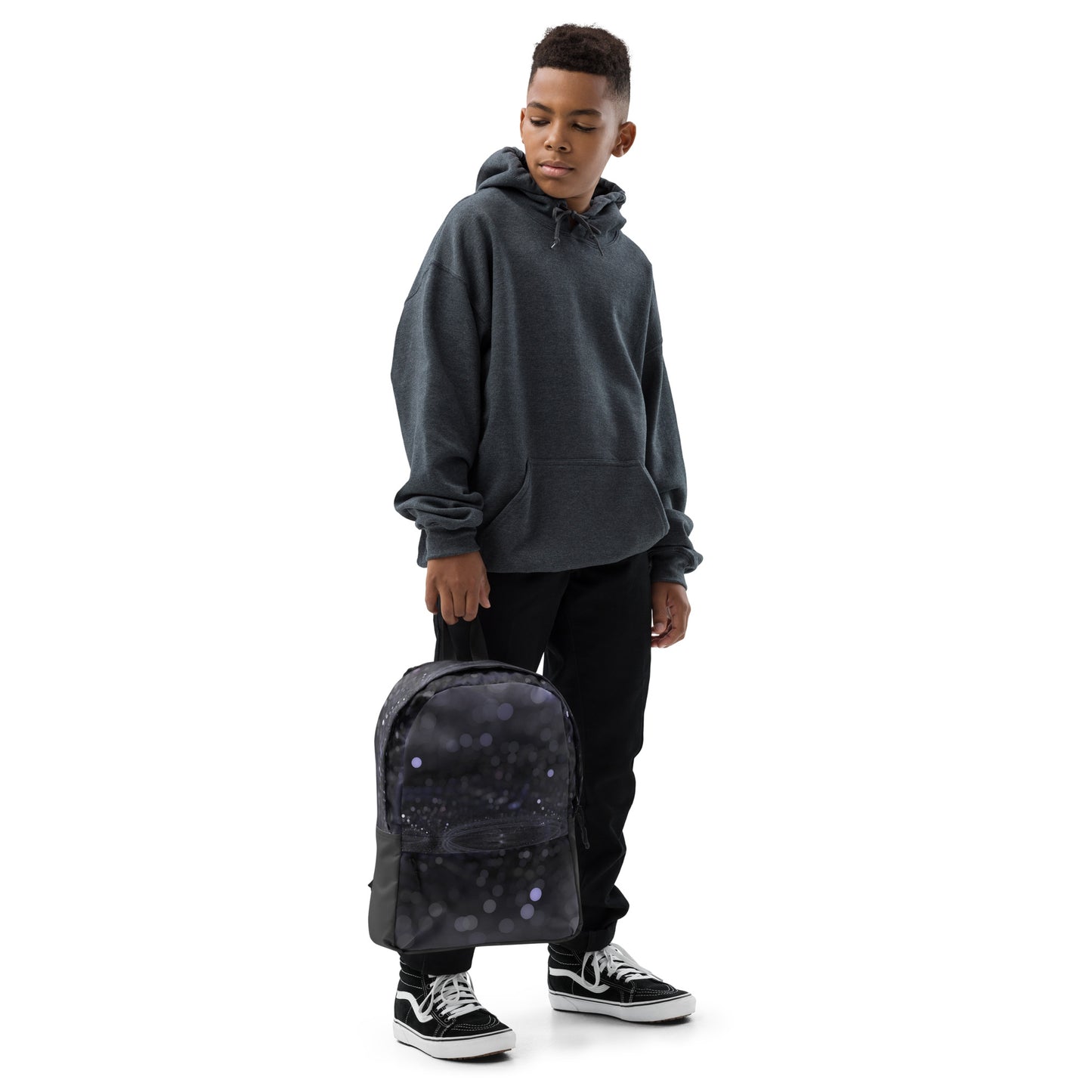 Young person holding a fashionable backpack with unique design by PJ Designs in black with circular patterns