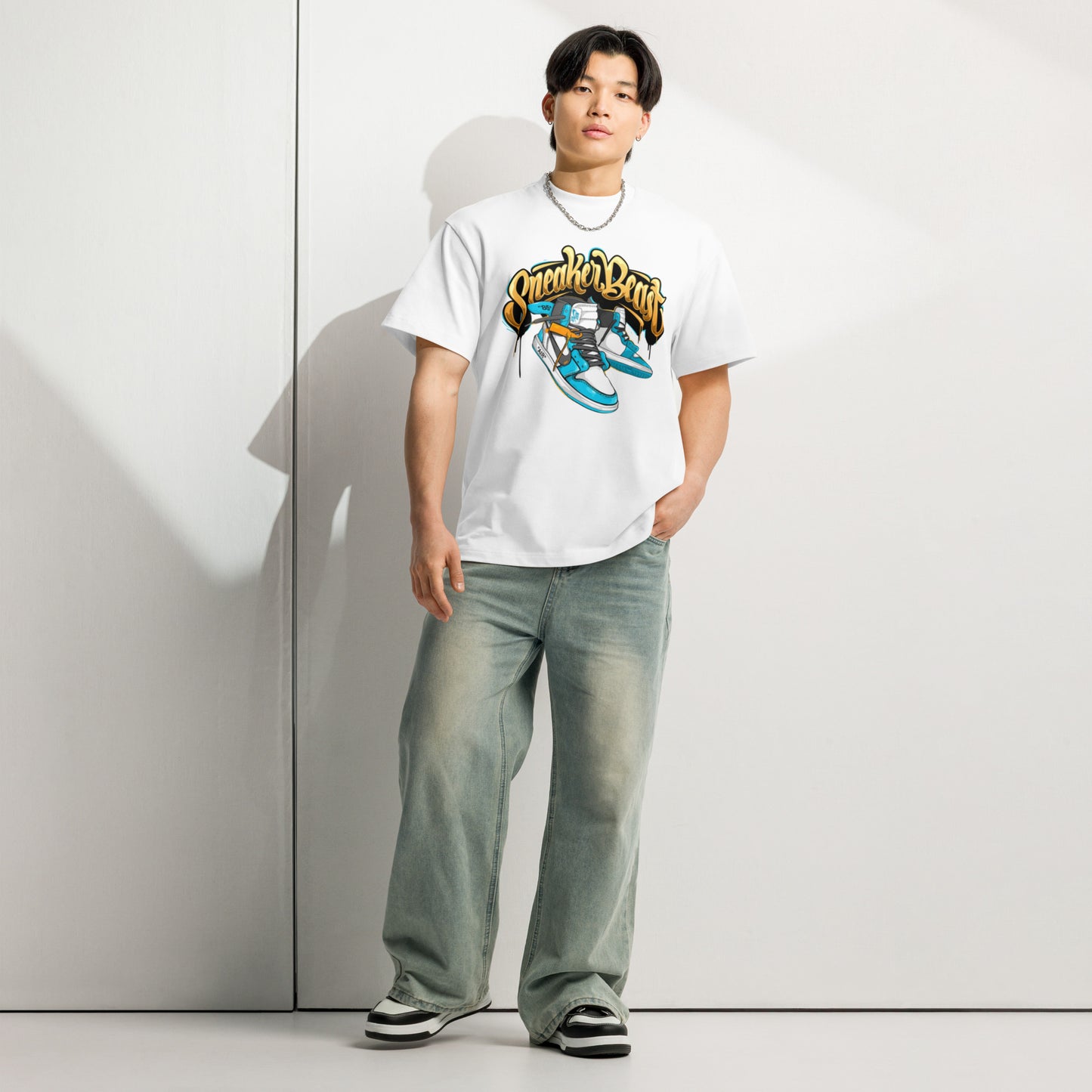 Male model wearing PJ Designs unisex street style box tee white graphic with relaxed jeans and sneakers