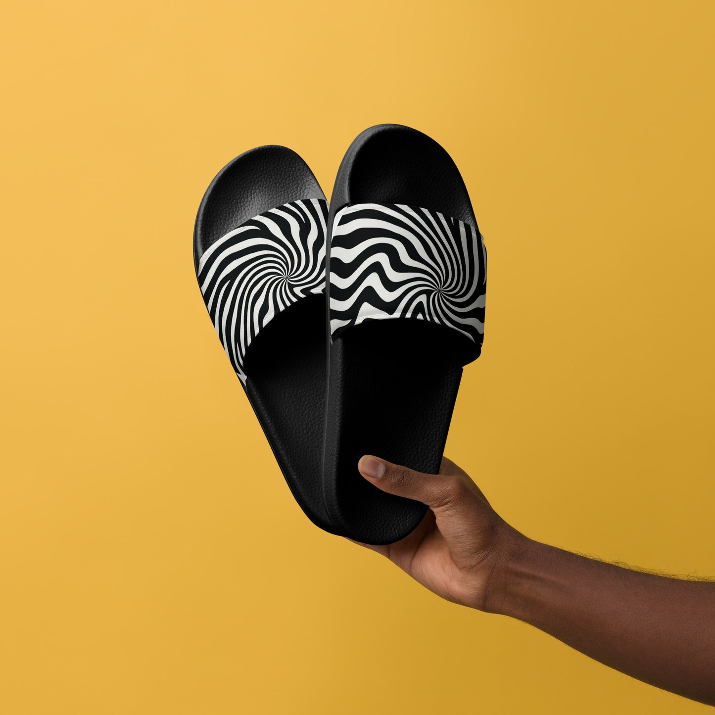 PJ Designs black and white streetwear slides for men with wavy pattern held against yellow background