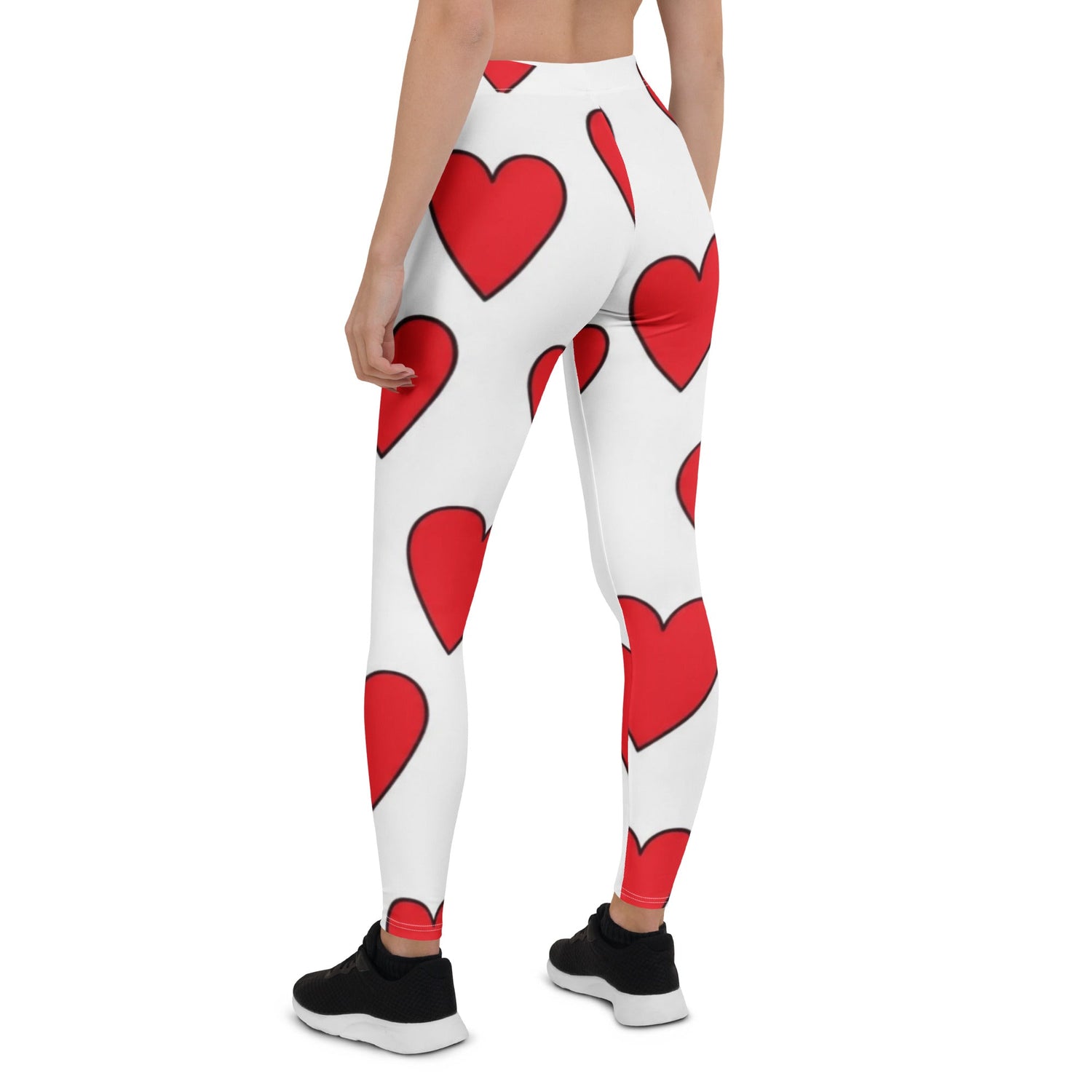 Woman wearing stylish gym wear white leggings with a bold red heart pattern and black athletic shoes