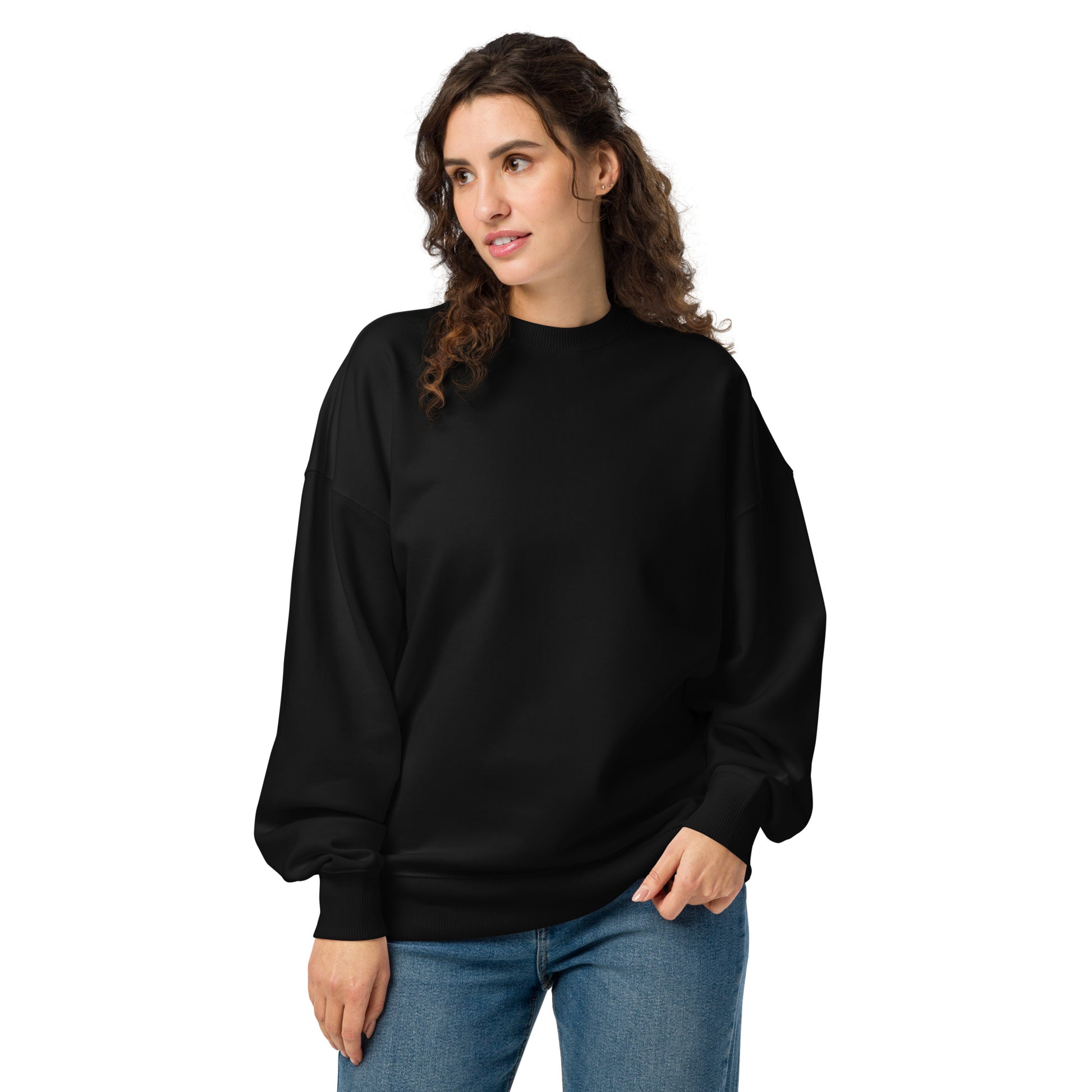 PJ Designs comfortable oversized crewneck sweatshirt in black worn by woman with curly hair and blue jeans