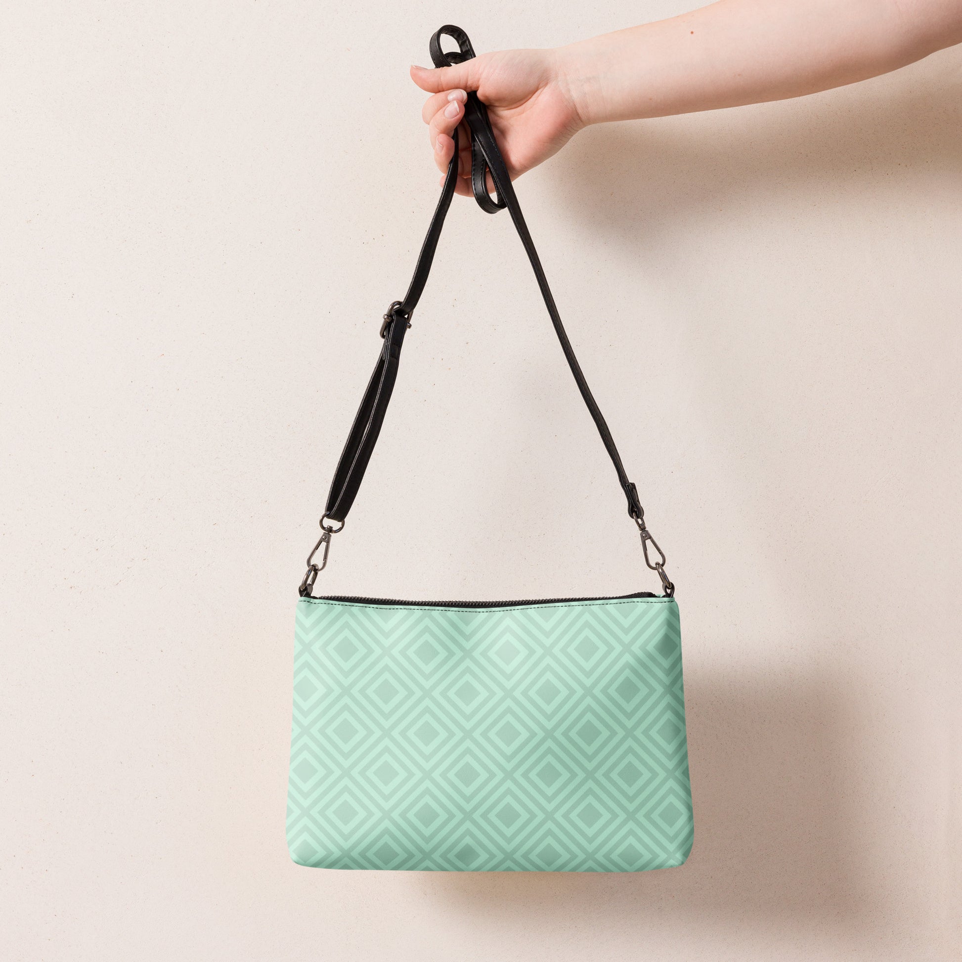 PJ Designs diamond pattern wristlet bag in light green held by a hand with black adjustable strap