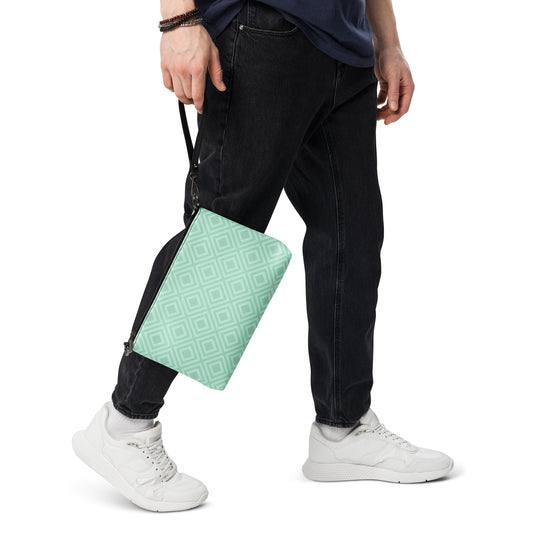 PJ Designs diamond pattern wristlet bag in light green held by person wearing black jeans and white sneakers