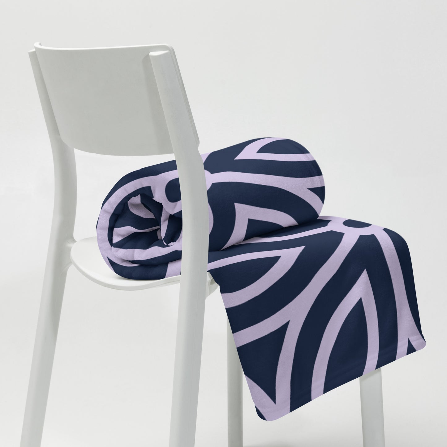 PJ Designs stylish cozy blankets for living room with modern navy blue and lavender geometric pattern draped over white chair