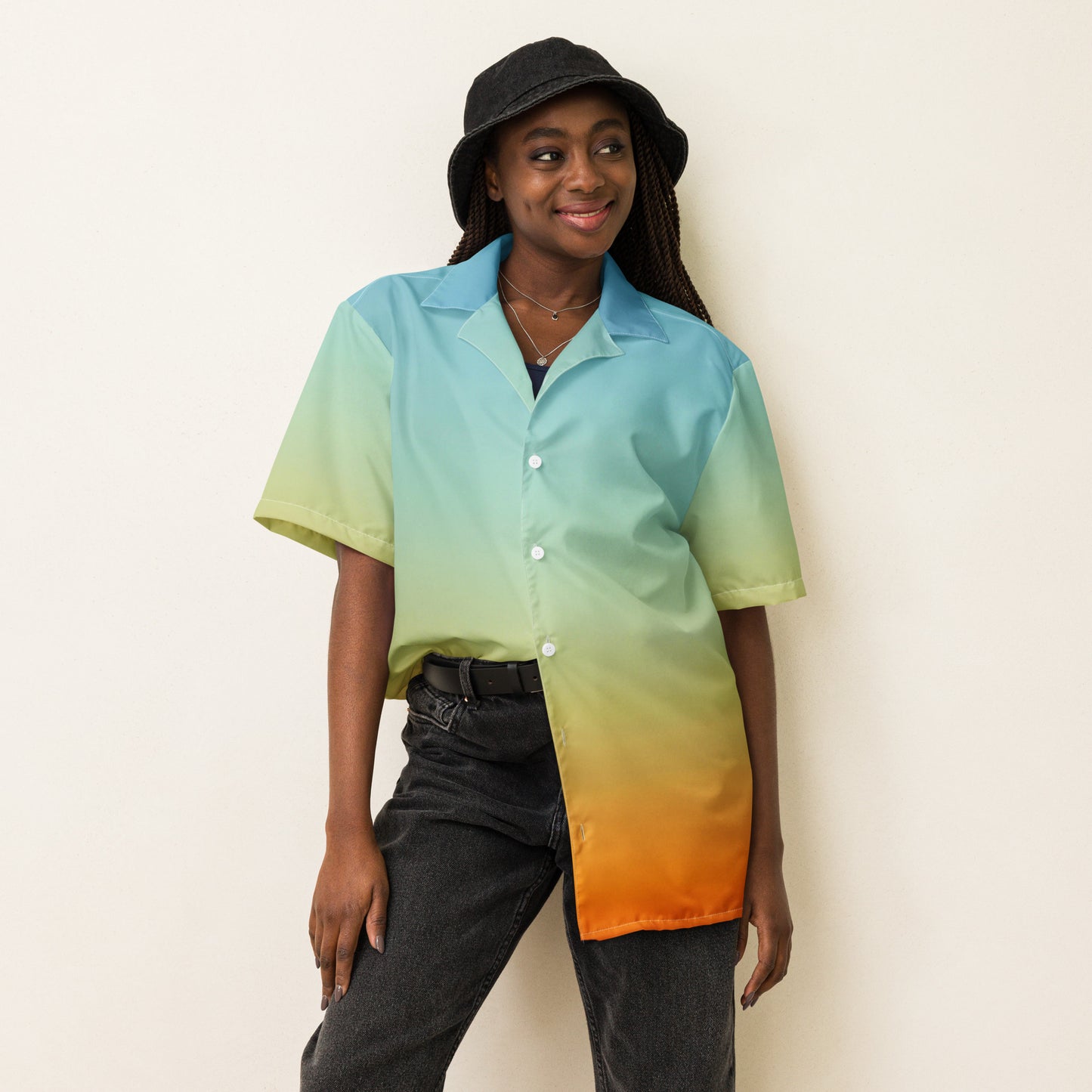PJ Designs summer short sleeve unisex shirt with gradient blue to orange color worn with black bucket hat and jeans
